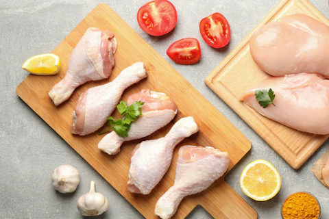 Composition with raw chicken meat on gray background