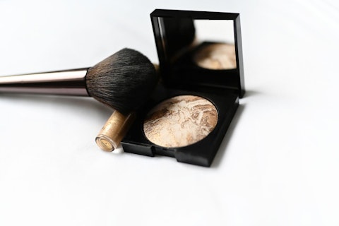 Eye Shadow Powder and Brush Against White Background