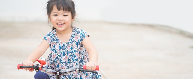 Happy Little Asian Girl on a Bicycle
