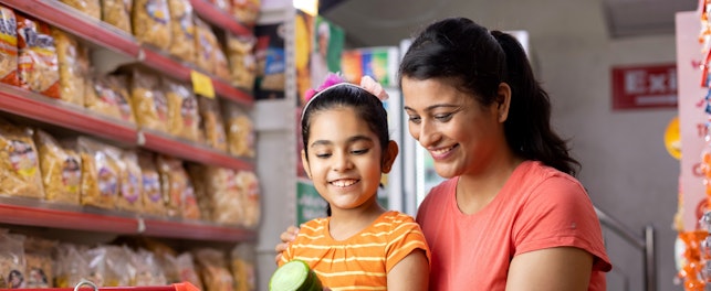 Happy Mother and Daughter Reading Product Information while Shopping at Supermarket