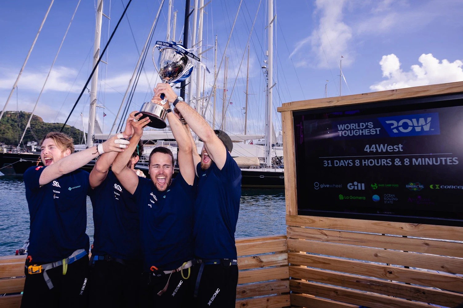 44 west holding the winners cup after rowing across the Atlantic