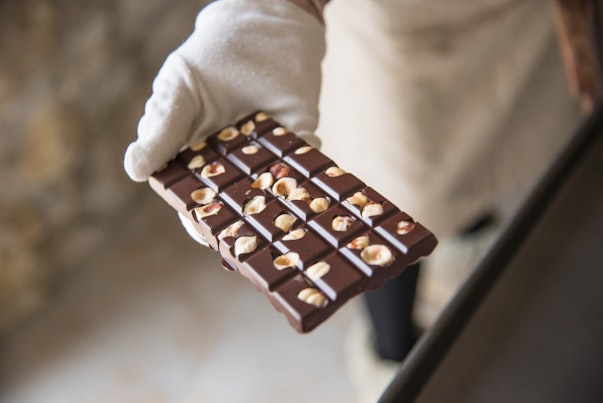 Chocolate Bar with Nuts Held by a Chef