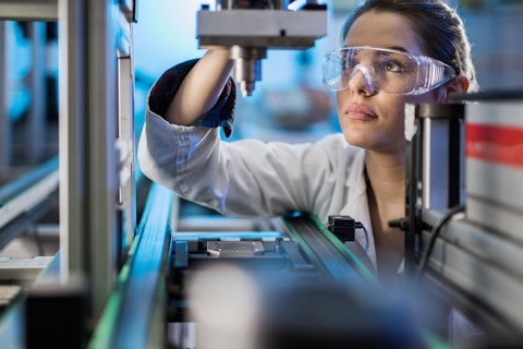 Engineer Examining Machine Part on a Production Line