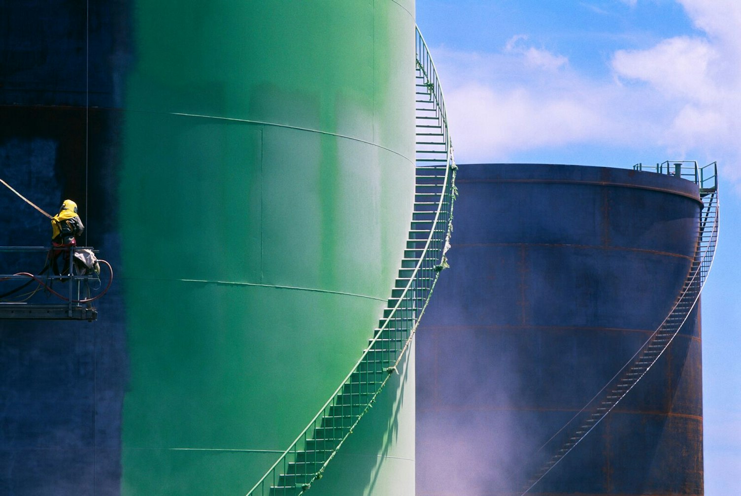 Technician Painting Oil Tanks