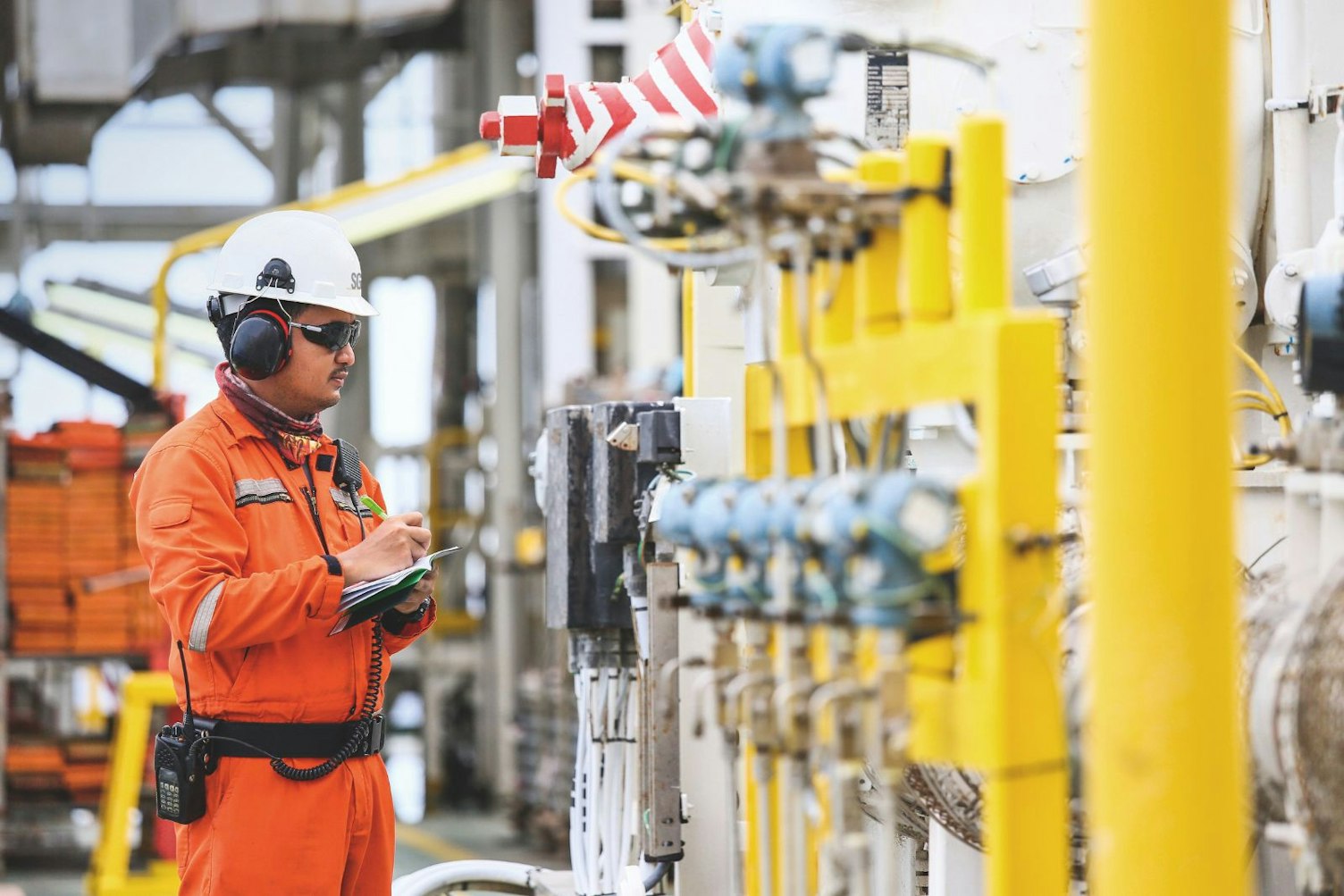 Worker Recording Operation on Oil Rig SGS Logo