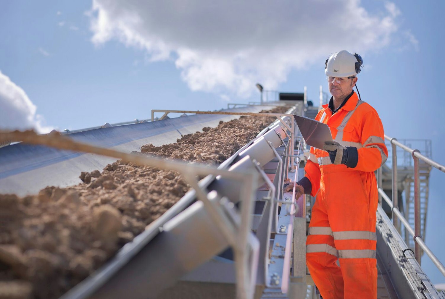 Worker Inspecting Stone Screening and Crushing Machine in Quarry